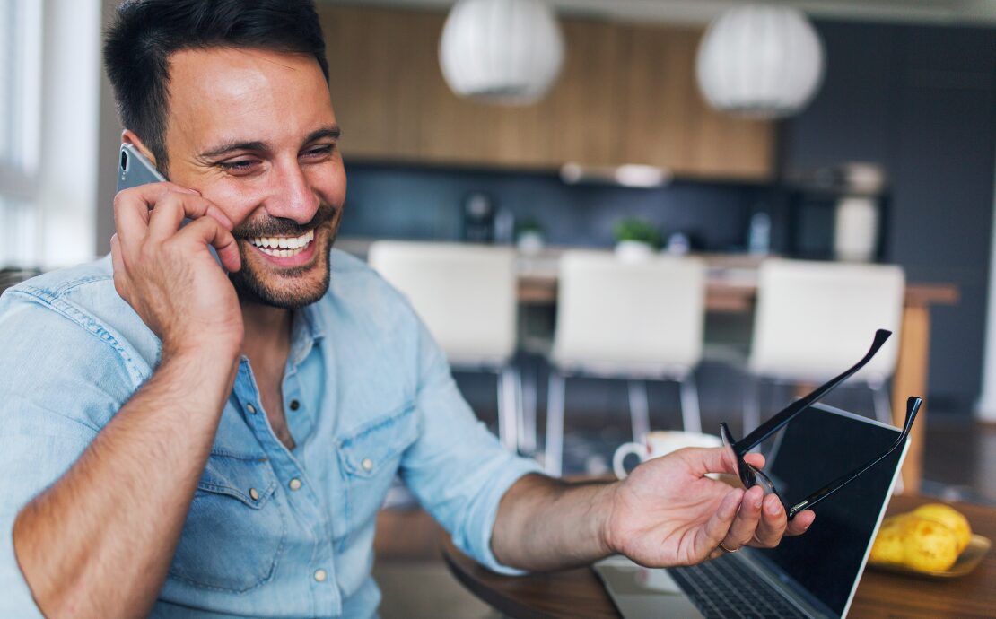 Man smiling while on a phone call