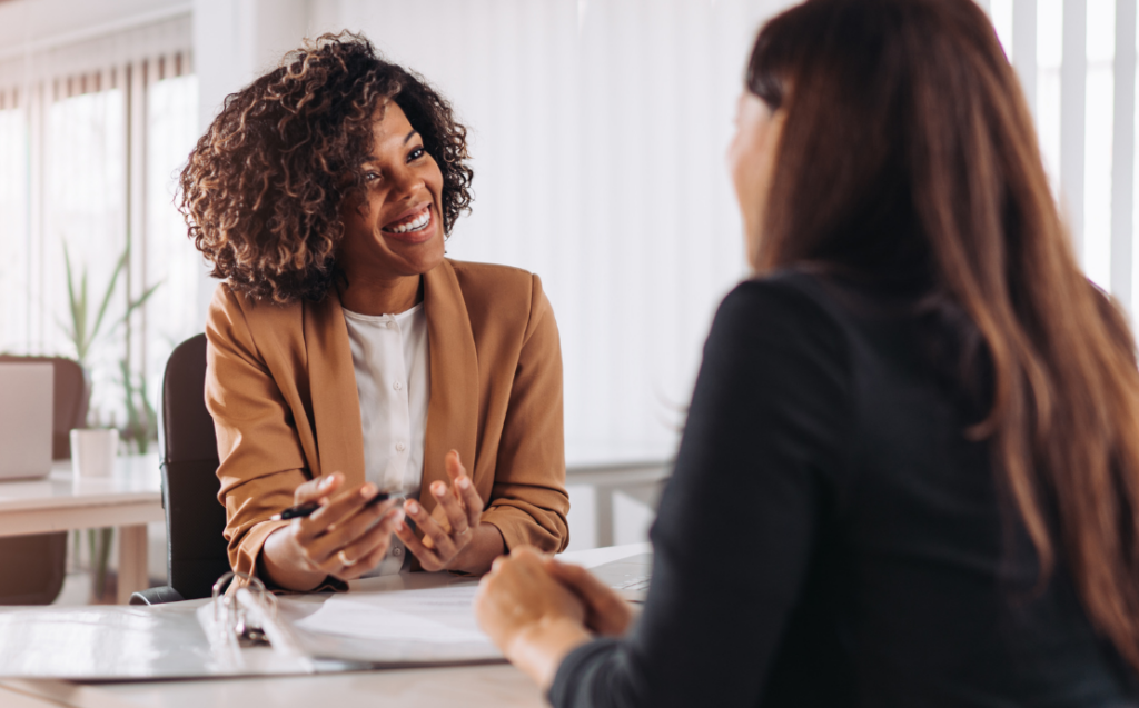 Two women sat at a desk, having a work meeting