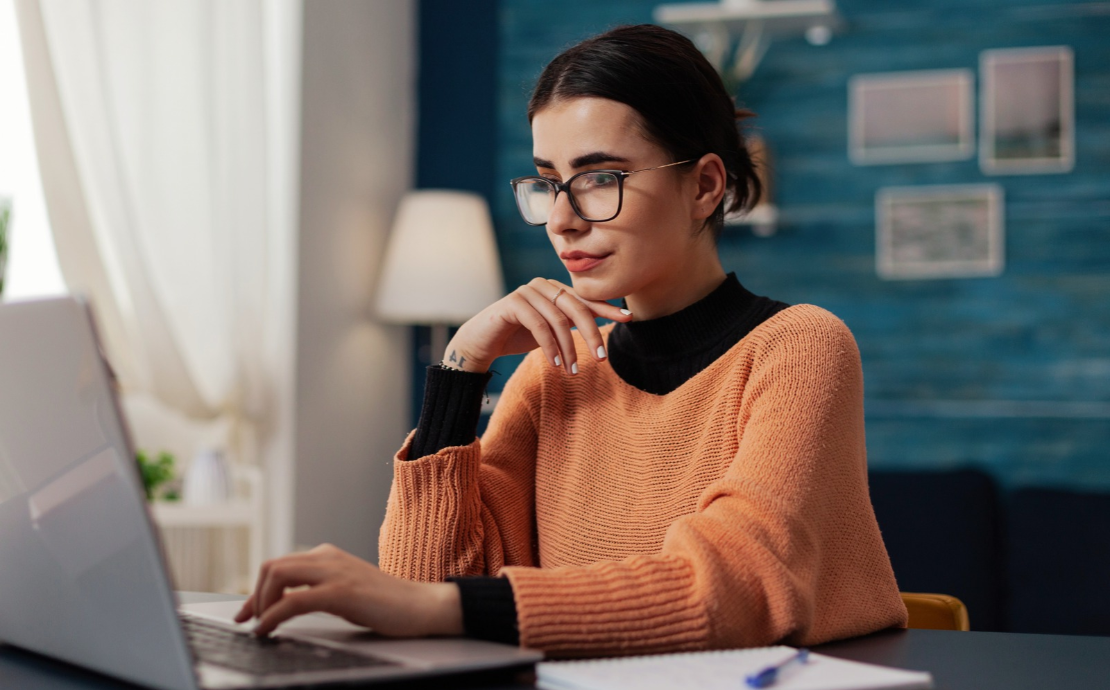Woman using a laptop at a desk in a modern workspace