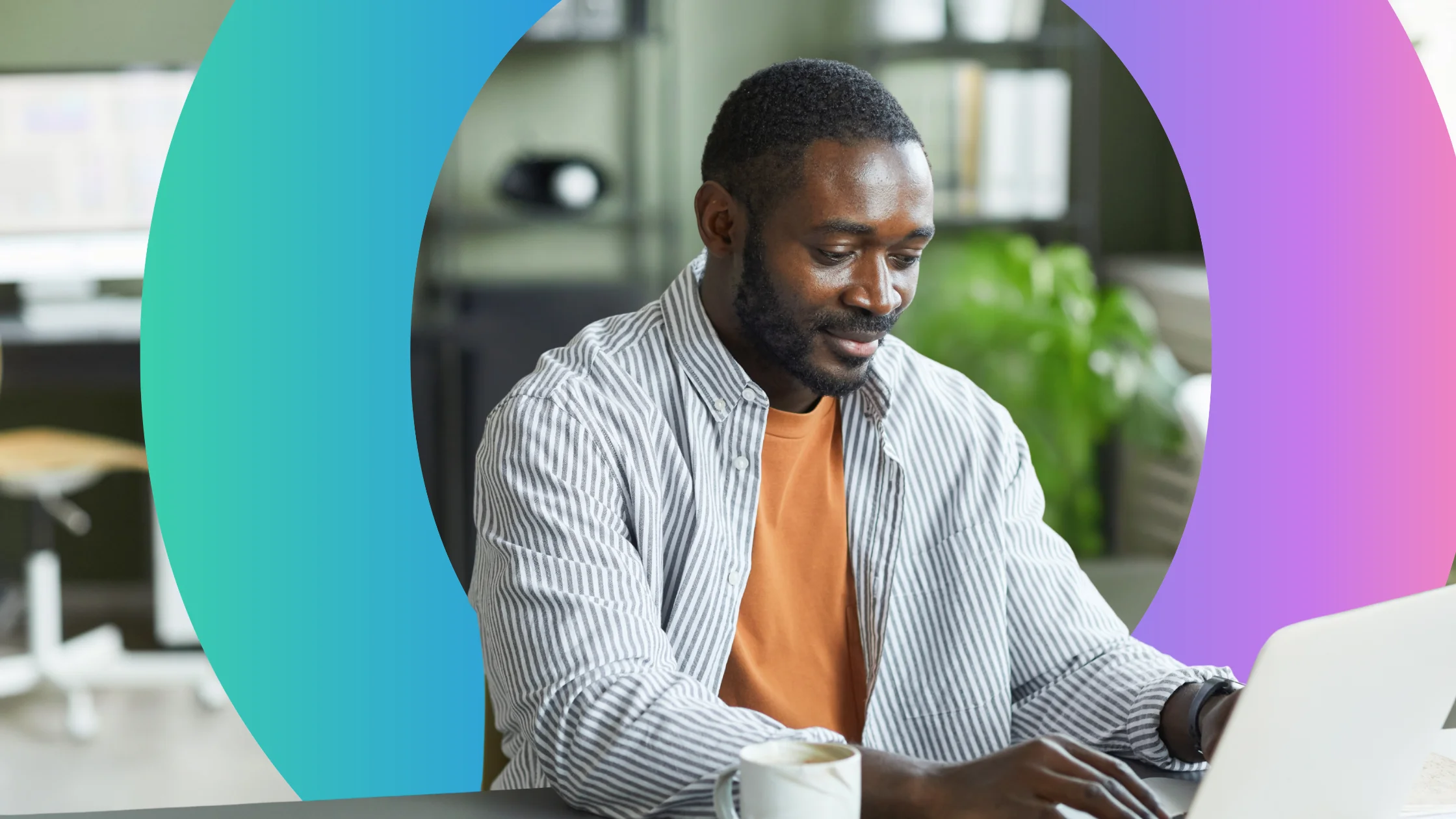 Man sat at desk in home office typing on a laptop